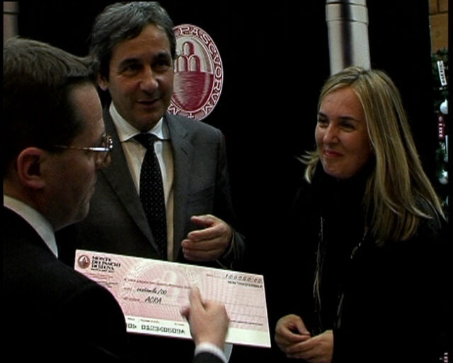 Rossi, responsabile area comunicazione del gruppo Montepaschi e Gianfranco Cenni consegnano l'assegno ad Elena Casolari di ACRA