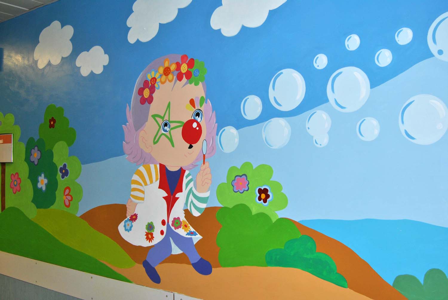 Ospedale a colori. I volontari clown decorano le pareti del reparto Pediatria di Siena