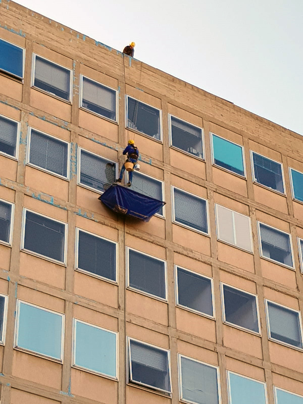 Manutenzione spettacolare. Squadra di edilizia acrobatica al lavoro sulla facciata dell’ospedale