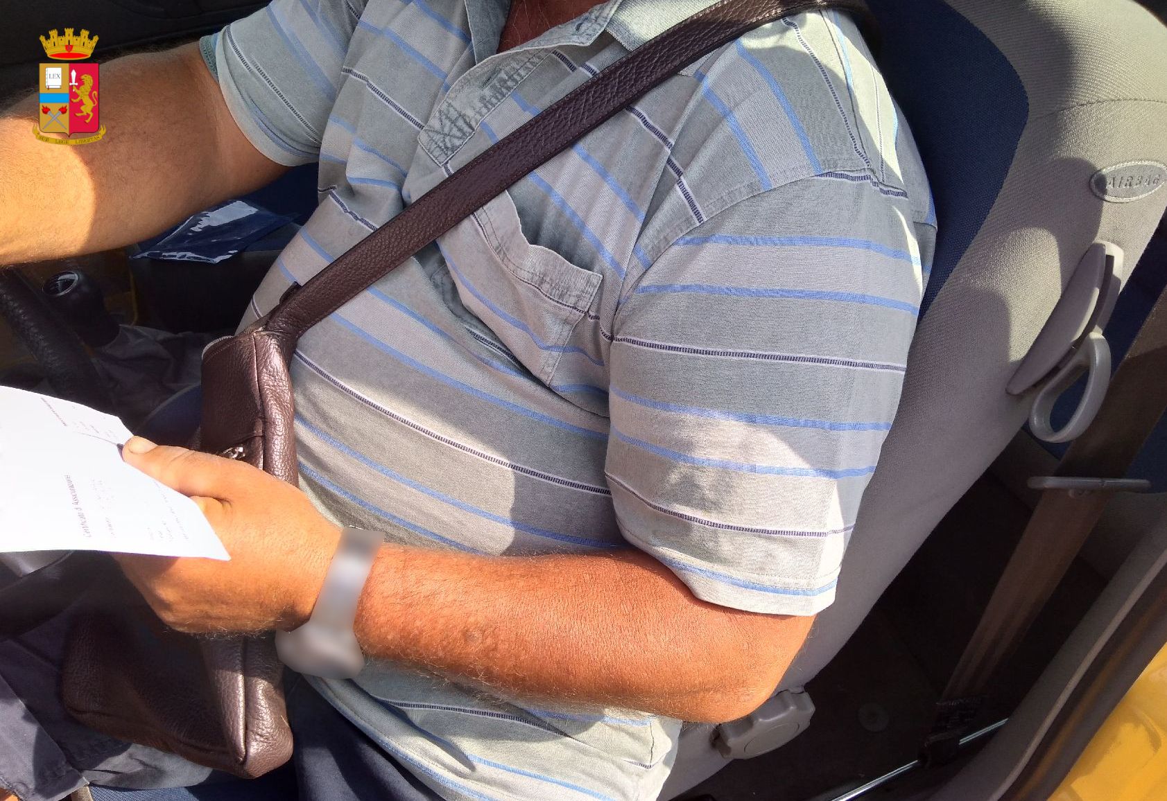 Creativo alla guida. Pistoia, al volante con tracolla borsa al posto della cintura, multato